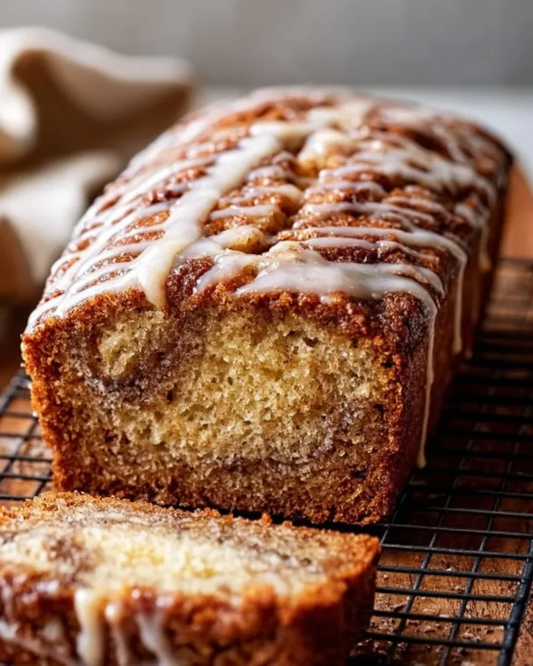 Freshly baked cinnamon swirl banana bread with a golden crust and swirls of cinnamon.